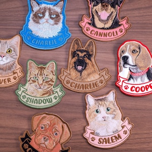 May include: A collection of embroidered pet patches featuring various dog and cat breeds. Each patch displays a detailed animal portrait above a ribbon banner with names like Charlie, Cannoli, Cooper, Shadow, and Salem, accented by paw print icons.