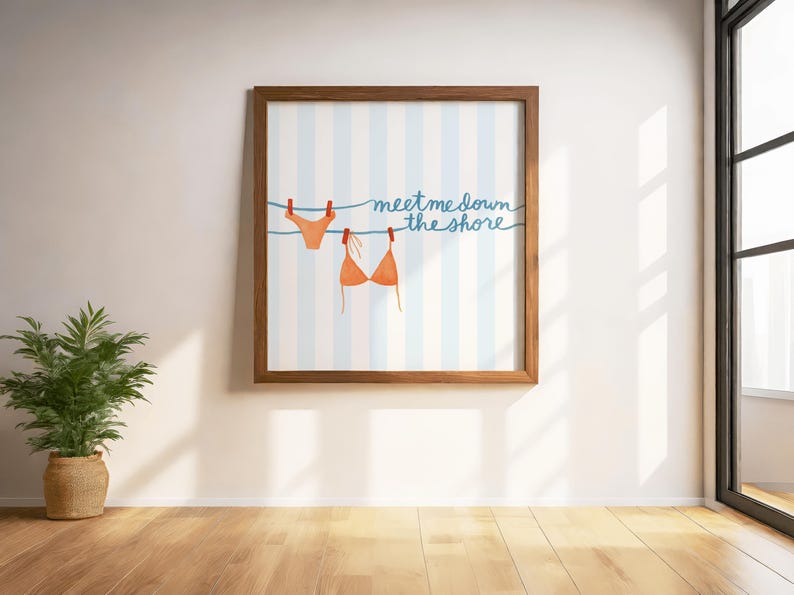 May include: A framed print featuring a watercolor illustration of a bikini top and bottom hanging on a clothesline. The background has blue and white stripes, and the text "meet me down the shore" is written in blue script.
