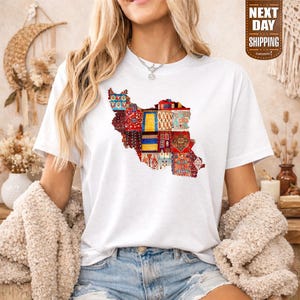 Puede incluir: Camiseta blanca con un mapa colorido de Irán, compuesto por varios diseños estampados. La camiseta tiene cuello redondo y mangas cortas. Las palabras "NEXT DAY SHIPPING" están impresas en una etiqueta marrón.