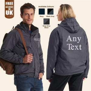Puede incluir: Una chaqueta gris oscura con capucha y cierre de cremallera. La chaqueta tiene un texto bordado en blanco en la parte posterior que dice "Any Text".