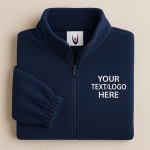 Könnte beinhalten: Marineblaue Fleecejacke mit durchgehendem Reißverschluss und Stehkragen. Auf der Vorderseite der Jacke steht in Weiß "YOUR TEXT/LOGO HERE". Ein kleines Logo ist oben auf dem Rücken sichtbar.