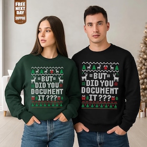 May include: Two Christmas-themed sweatshirts, one dark green and one black. Each has a pattern of reindeer, trees, and the text "BUT DID YOU DOCUMENT IT???" in white. A festive apparel item for the holiday season.