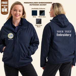 Könnte beinhalten: Eine marineblaue, bestickte Outdoor-Jacke mit Kapuze. Die Jacke hat einen Reißverschluss und zwei Taschen. Die Vorderseite der Jacke zeigt ein kleines besticktes Logo mit der Aufschrift "Be The Shine". Die Rückseite der Jacke hat eine große bestickte Fläche mit der Aufschrift "Your Text Embroidery".