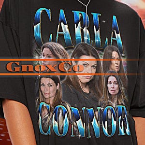 May include: Black oversized t-shirt with a graphic print of a woman's face and the text "CARLA CONNOR" in blue and white. The text "Gnox Co" is also printed on the shirt.