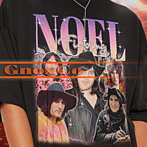 Puede incluir: Camiseta unisex negra con foto de banda y texto "NOEL Fielding" y "Gnox Co". La camiseta tiene mangas cortas y un corte oversize. La modelo lleva una talla 2XL.