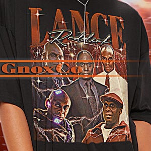 May include: Black oversized t-shirt with a graphic featuring the text "LANCE Reddick" and images of several men. The shirt also has the text "GnoxCo" in orange. The background is a red and orange lightning design.