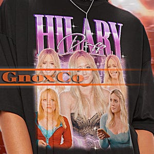 Könnte beinhalten: Schwarzes Oversize-T-Shirt mit einem Grafikdruck von Hilary Duff. Der Text "Hilary Duff" ist in Lila und Pink auf einem rosa und lila Hintergrund gedruckt. Die Grafik zeigt vier Bilder von Hilary Duff.