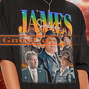 May include: Black unisex t-shirt featuring a graphic of James Spader and the text "JAMES Spader". The shirt has a crew neck and short sleeves. The background is a lightning-like design.