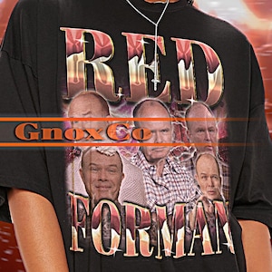 May include: Black unisex t-shirt with a graphic print of the text "RED" and "FORMAN" in a retro style. The graphic also features several images of people.