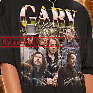 Puede incluir: Camiseta unisex negra con el nombre "GARY" en una fuente estilizada y un collage de imágenes. La camiseta tiene el texto "TSHIRT Unisex" en la parte superior. El diseño incluye gráficos de rayos.