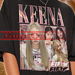以下が含まれることがあります： ピンク色のフォントで「KEENA」という文字が入った黒色のユニセックスTシャツ。女性グループのグラフィックと「FIFTY FIFTY」の文字が特徴です。Tシャツの上部には「TSHIRT Unisex」と書かれています。
