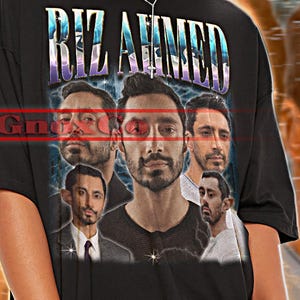 Puede incluir: Camiseta unisex negra con el nombre "RIZ AHMED" en una fuente estilizada y un collage de imágenes del actor. La camiseta también tiene el texto "TSHIRT Unisex" en la parte superior. La modelo lleva una camisa 2XL.