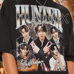 Può includere: T-shirt unisex nera con una grafica in stile vintage di un gruppo musicale e la parola "HUNTER". La maglietta presenta anche il testo "Papun.com" e "entiallamong". La maglietta è etichettata "TSHIRT Unisex".