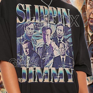 Peut inclure: T-shirt unisexe noir avec l'inscription "SLIPPIN' JIMMY" et un collage d'images. Le t-shirt porte également l'inscription "TSHIRT Unisex" en haut. Le modèle porte une taille 2XL.