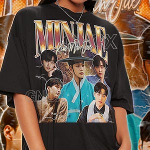 May include: Black unisex t-shirt featuring a graphic of multiple people and the text "MINAJAE Kim Min Jae". The shirt also has the text "TSHIRT Unisex" at the top. The model wears a 2XL shirt.