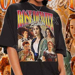 May include: Black unisex t-shirt with a graphic from the film "Titanic", featuring the text "ROSE DEWITT Bukater". The design has a vintage aesthetic, with images of the main characters. The words "TSHIRT Unisex" are at the top.