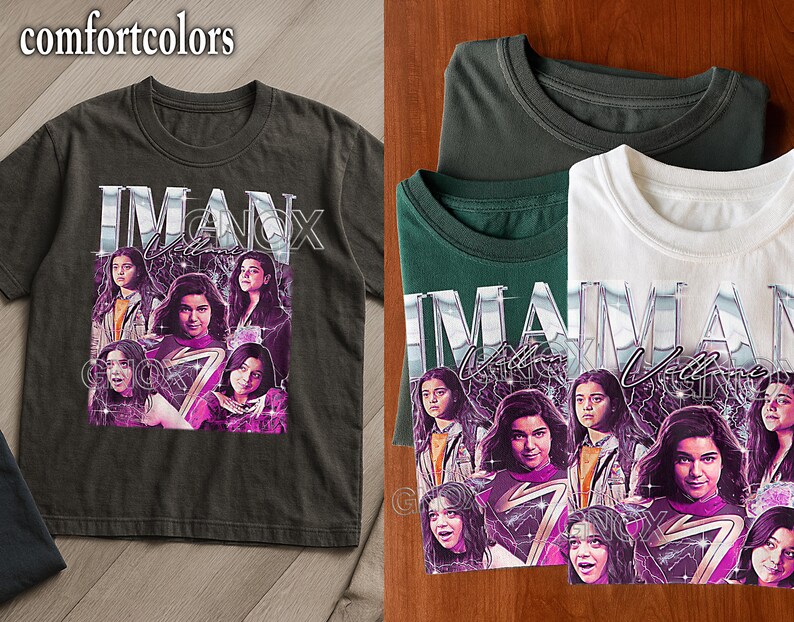 May include: Dark grey Comfort Colors t-shirt featuring a graphic of a woman's face with the text "IMAN Vellani". The design includes a purple and white lightning bolt and multiple images of the woman. Several folded t-shirts are also visible.