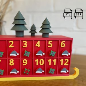 Può includere: Calendario dell'Avvento rosso con dodici scomparti numerati. Il calendario presenta decorazioni di alberi di Natale verdi sulla parte superiore e icone festive su ogni scomparto. Il calendario è progettato per assomigliare a una slitta.