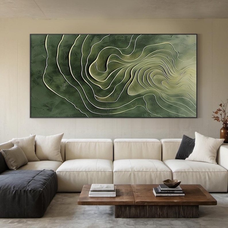 K&ouml;nnte beinhalten: Abstrakte Wandkunst mit einem gr&uuml;n-wei&szlig;en Wirbelmuster. Das Kunstwerk ist in einem schwarzen Rahmen gerahmt und h&auml;ngt an einer Wand &uuml;ber einem wei&szlig;en Ecksofa.