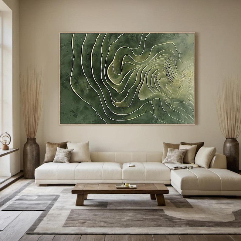 K&ouml;nnte beinhalten: Abstrakte Wandkunst in Gr&uuml;n und Wei&szlig; mit einem wirbelnden, geschichteten Design. Das Kunstwerk ist gerahmt und h&auml;ngt an einer beigefarbenen Wand &uuml;ber einem wei&szlig;en Ecksofa.