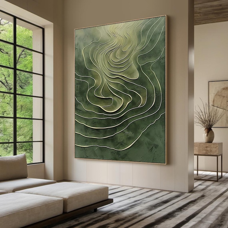 K&ouml;nnte beinhalten: Abstrakte Wandkunst in Gr&uuml;n und Wei&szlig; mit einem wirbelnden, strukturierten Design. Das Kunstwerk ist in einem d&uuml;nnen, goldenen Rahmen gerahmt.