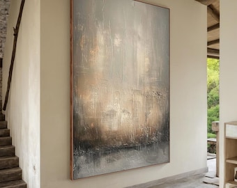 Op de afbeelding: Groot abstract schilderij met een getextureerd oppervlak. Het kunstwerk toont een mix van neutrale kleuren, waaronder grijs, beige en bruin, waardoor een gevoel van diepte en dimensie ontstaat. Het schilderij is ingelijst in een houten lijst.