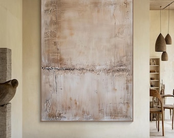 May include: Large abstract painting with a neutral color palette. The artwork features a textured surface with shades of beige, brown, and white. A horizontal line of dark brown accents the center, and the piece is framed in a thin, light brown frame.