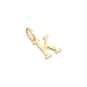 May include: A polished gold-tone metal pendant in the shape of the capital letter K. The letter features a classic serif typeface design with clean, straight lines and a small, circular jump ring attached to the top left corner for hanging.