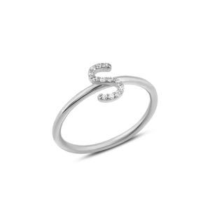 Puede incluir: Un anillo plateado con la letra "S" incrustada con peque&ntilde;as piedras preciosas transparentes. El anillo tiene un dise&ntilde;o delicado y minimalista, con la letra como punto focal. El anillo est&aacute; sobre un fondo blanco.