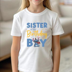 a little girl wearing a white shirt that says sister of the birthday boy