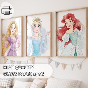 May include: Three framed art prints featuring cartoon princesses: Rapunzel in a purple dress, Elsa in a blue dress, and Ariel with red hair. The prints are displayed on a white wall with decorative bunting. The text "HIGH QUALITY GLOSS PAPER 250G" is at the bottom.