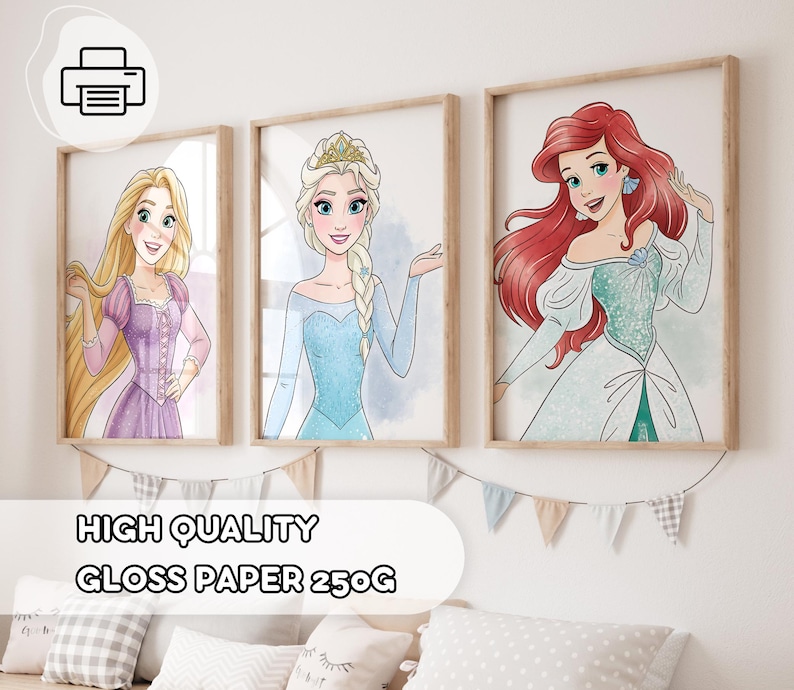 May include: Three framed art prints featuring cartoon princesses: Rapunzel in a purple dress, Elsa in a blue dress, and Ariel with red hair. The prints are displayed on a white wall with decorative bunting. The text "HIGH QUALITY GLOSS PAPER 250G" is at the bottom.