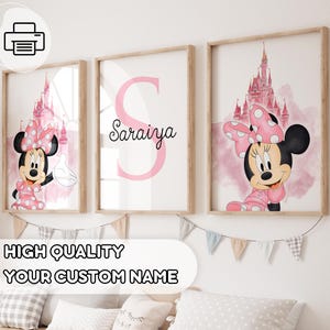 May include: Three framed prints featuring Minnie Mouse and a pink castle. One print has the letter "S" and the name "Saraiya". The prints are in wooden frames and are decorated with a banner that says "HIGH QUALITY YOUR CUSTOM NAME".