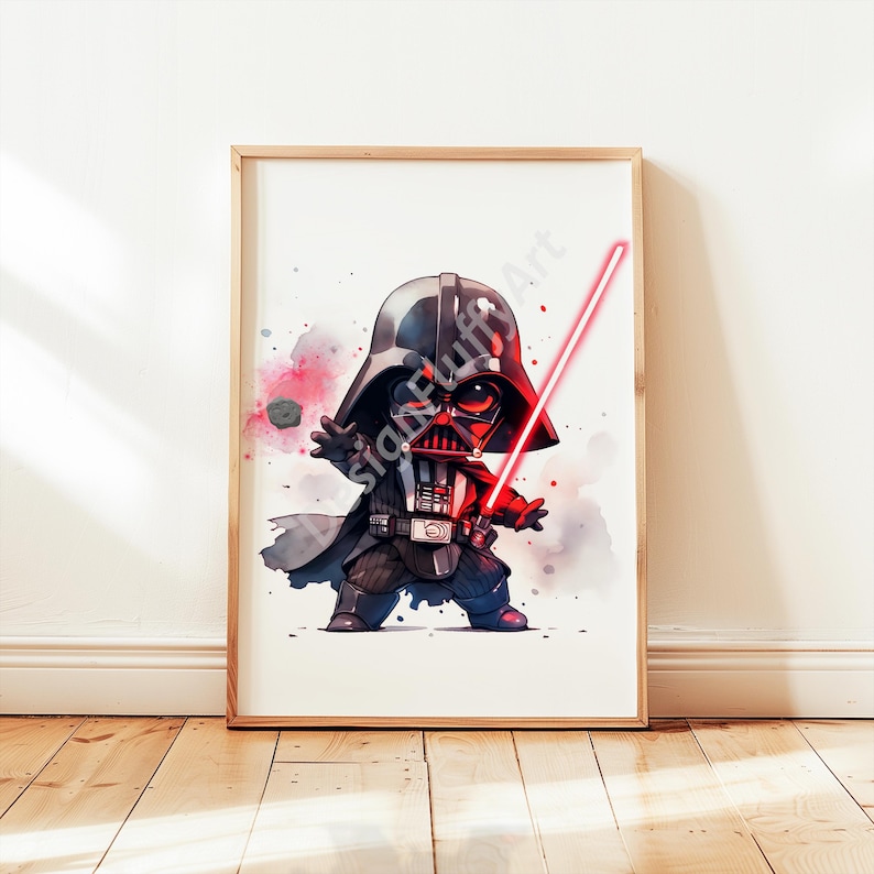 Op de afbeelding: Een ingelijste aquarelprint van een cartoon Darth Vader met een rood lichtzwaard. Het kunstwerk toont een chibi-achtig personage met een zwarte helm en cape, tegen een witte achtergrond met kleurrijke spetters. De lijst is lichtbruin.