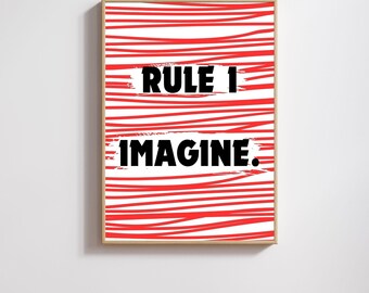May include: A framed art print featuring a white backdrop with red horizontal lines. The words "RULE 1" and "IMAGINE." are in a bold, black font. The artwork is presented in a wooden frame.