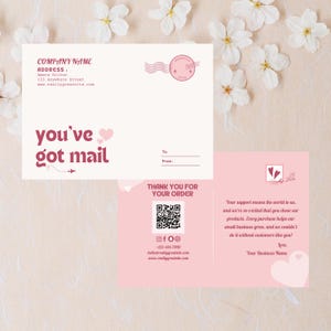 以下が含まれることがあります： 「you've got mail」のピンク色の文字が入ったクリーム色の封筒と、お揃いのピンク色のサンキューカードが特徴の文具セット。封筒には会社名、住所、ウェブサイトが記載されています。