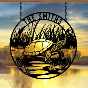 May include: Black metal silhouette of a turtle walking on a path in a pond with tall grass. The silhouette is in a circle with the text "The Smiths" at the top.