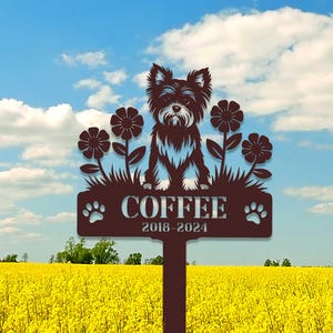Könnte beinhalten: Ein braunes Garten Schild aus Metall mit einer Silhouette eines Yorkshire Terrier Hundes, der vor Blumen steht. Das Schild trägt die Aufschrift "COFFEE 2018-2024" mit Pfotenabdrücken auf beiden Seiten.
