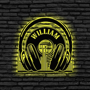 Könnte beinhalten: Ein schwarzes und gelbes Neon-Schild mit dem Wort "WILLIAM" in einem Kreis, umgeben von Kopfhörern und Schallwellen.