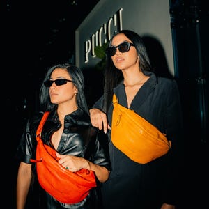 Two women wearing modern leather hip bags, one in vibrant red and the other in bold yellow. Perfect for festivals and everyday carry, these stylish crossbody fanny packs offer a trendy way to carry essentials while adding a pop of color.