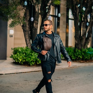 A man wearing the leather side bag as a shoulder bag, paired with a black outfit. Perfect as a fanny pack, a gift for him or her.