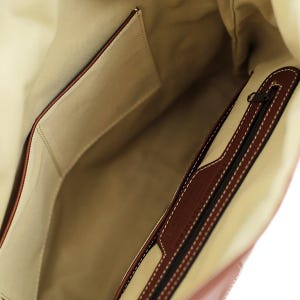 Interior view of the leather bag, showcasing the pockets and detailed stitching.