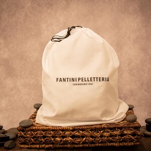 Cotton bag used for packaging the unisex full-grain leather backpack or bag, featuring simple, and chic design for protection during shipping.