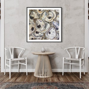 May include: A framed painting of a cluster of oyster shells in shades of white, gray, and brown. The shells are arranged in a random pattern, creating a textured and organic look.