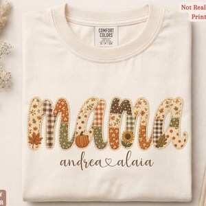 Personalized Mama Comfort Colors shirt with custom kids names, fall patchwork letters, pumpkins, florals, and faux embroidery effect in warm autumn tones on an ivory tee.