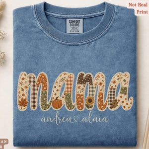 Personalized Mama Comfort Colors shirt with custom kids names, fall patchwork letters, pumpkins, florals, and faux embroidery effect in warm autumn tones on a blue jean tee.