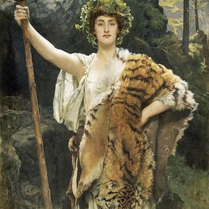 Puede incluir: Una mujer con un vestido blanco y una piel de tigre drapeada sobre sus hombros se encuentra de pie en un entorno boscoso. Sostiene un bastón rematado con una piña en su mano derecha. Lleva una corona de hojas en la cabeza.