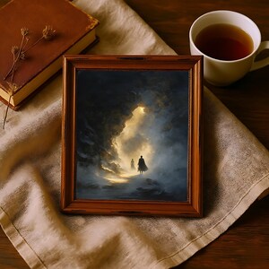 May include: A framed artwork with a dark, moody landscape scene. The painting depicts two figures walking towards a bright light within a cave-like structure. The frame is a warm, reddish-brown color. A cup of tea and a book are also in the image.