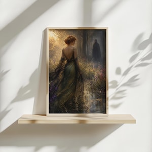 May include: Framed art print depicting a woman in an elegant gown walking through a sunlit forest path. The artwork features a palette of greens, golds, and purples, with a figure in the distance. The print is displayed on a wooden shelf against a white wall.