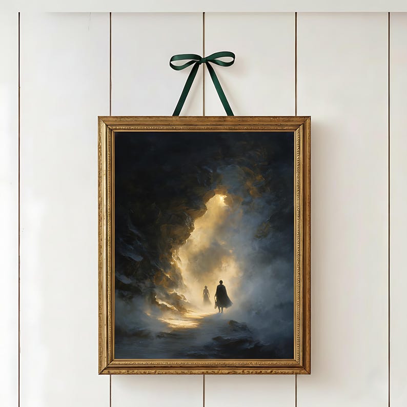 May include: Framed art print featuring a dramatic landscape with two silhouetted figures walking towards a bright light. The artwork is in a gold-colored frame and is suspended by a green ribbon.